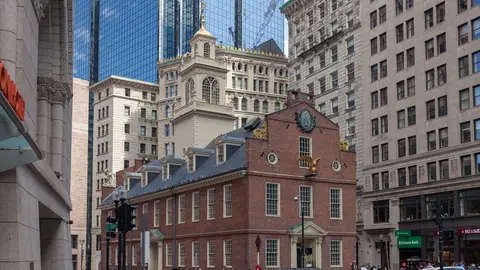 The red-brick Old State House in downtown Boston, with its gilded lion and unicorn and a white steeple, surrounded by modern office towers