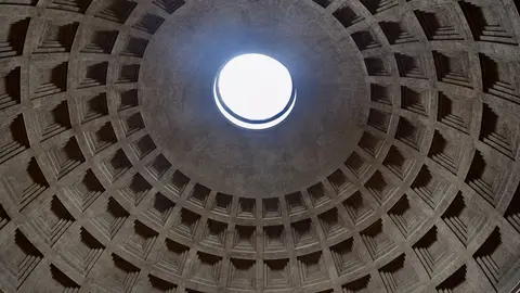 Looking straight up inside the Pantheon: rings of square coffers in the concrete dome narrowing toward the open oculus and its disc of daylight