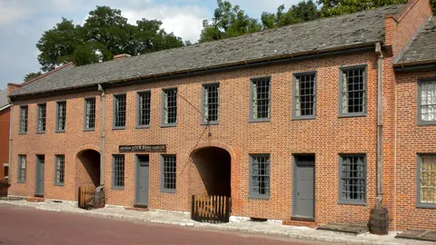 The red-brick First Missouri State Capitol buildings on the brick-paved South Main Street in St. Charles, Missouri, with two arched passageways and gray shutters